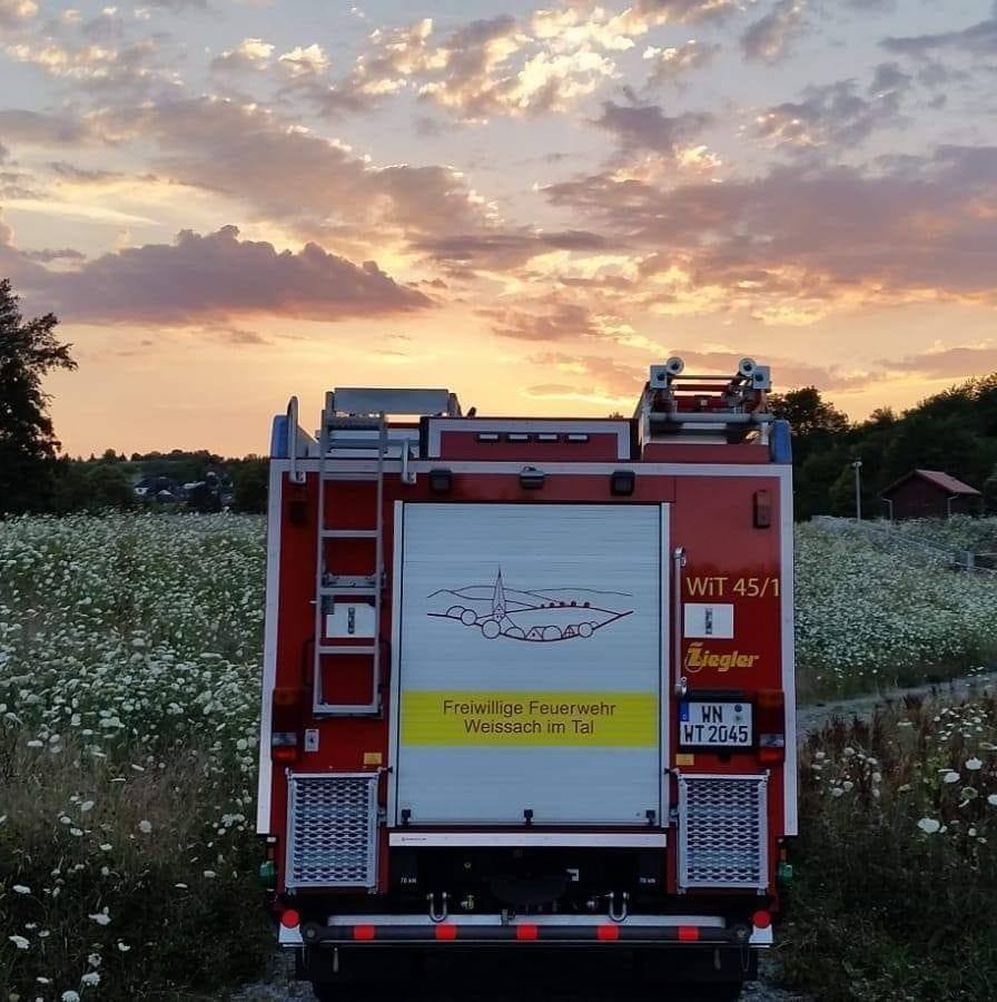 Feuerwehrauto von hinten vor einem Sonnenuntergang im Weissacher Tal